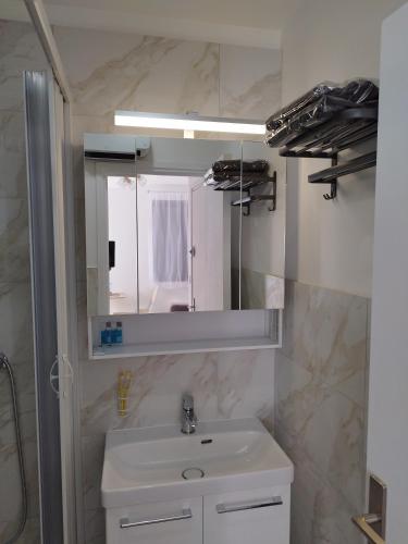 une salle de bain avec un lavabo et un miroir dans l'établissement Studio résidence les Miramars, au Barcarès