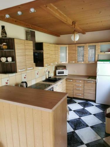 a kitchen with wooden cabinets and a checkered floor at Nina Kopalino in Kopalino