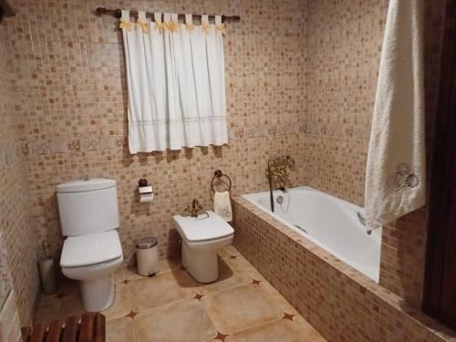a bathroom with a toilet and a bath tub at Como en casa in Alcaracejos