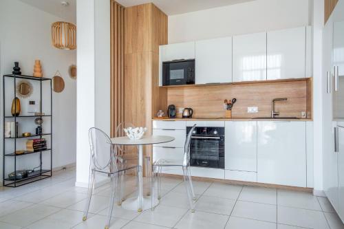 une cuisine avec des armoires blanches et une table et des chaises dans l'établissement Hyper centre vue bords Loire #confort #luxe, à Tours