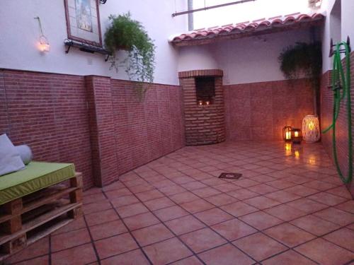 a large courtyard with a brick wall and a fireplace at Como en casa in Alcaracejos
