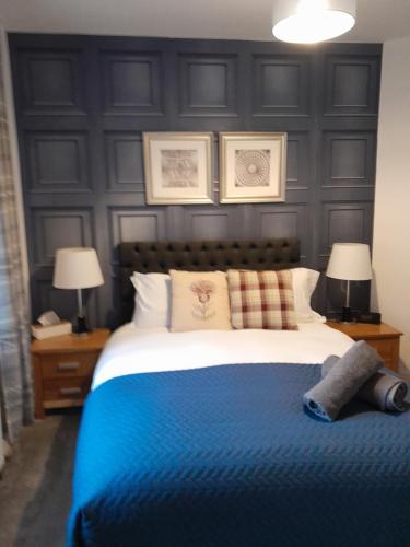 a bedroom with a blue bed with two lamps at WELCOMEHOUSE close to east beach, shops, restaurants and RAF base in Lossiemouth