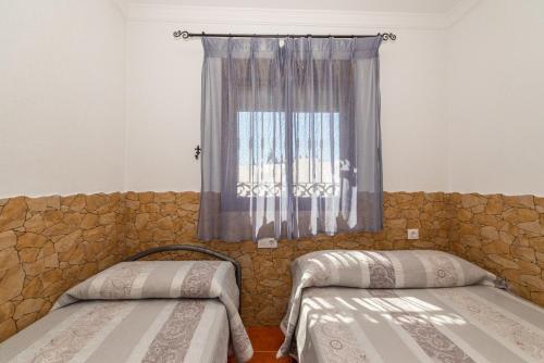 a bedroom with two beds and a window at Matilde&Leire in Barbate