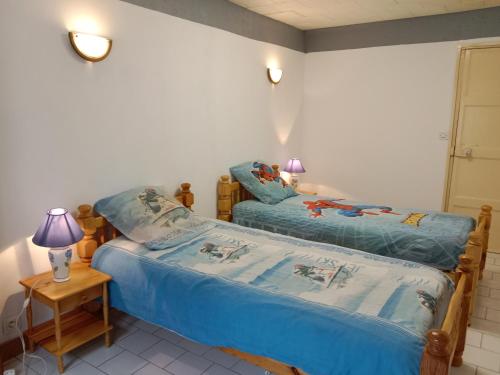 une chambre avec deux lits et une table avec une lampe dans l'établissement La petite maison des villages, à Saint-Christophe-en-Bazelle