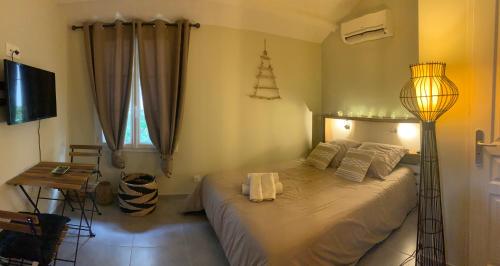 - une chambre avec un lit et une lampe dans l'établissement Le nid, à Bourg-lès-Valence