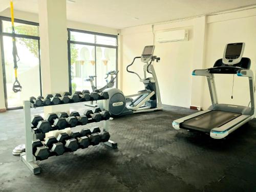 a gym with two treadmills and exercise machines at Aldea del Bazar in Tehuacán
