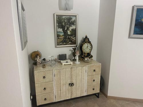 a wooden dresser with a clock on top of it at Apartments Smiljanic in Tribunj