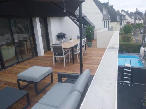 a patio with a table and chairs and a swimming pool at La " Villa " du JET in Ergué-Gabéric
