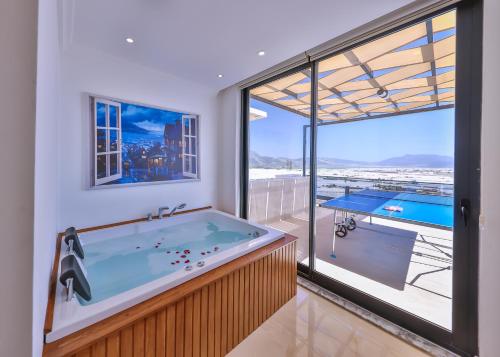 eine Whirlpool-Badewanne in einem Zimmer mit großem Fenster in der Unterkunft Villa Lalezar in Çavdır