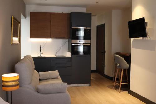 a living room with a couch and a kitchen at La Quinta del Sordo in Luarca