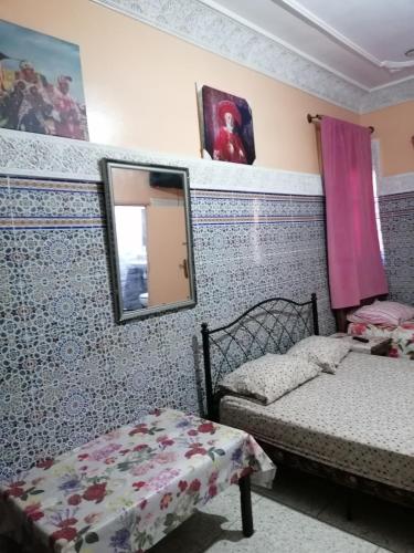 a bedroom with a mirror and two beds in it at La Perle in Meknès