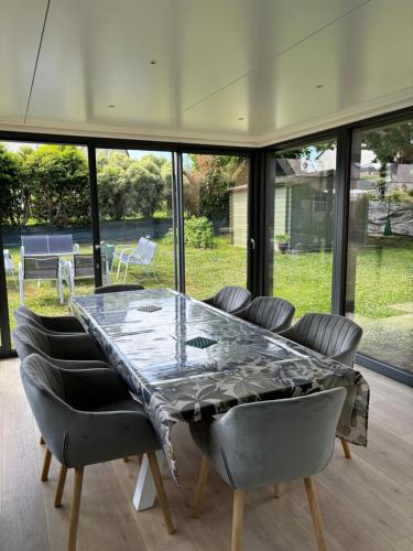 une salle à manger avec une grande table et des chaises en verre dans l'établissement Charmante maison centre-ville Perros-Guirec, à Perros-Guirec