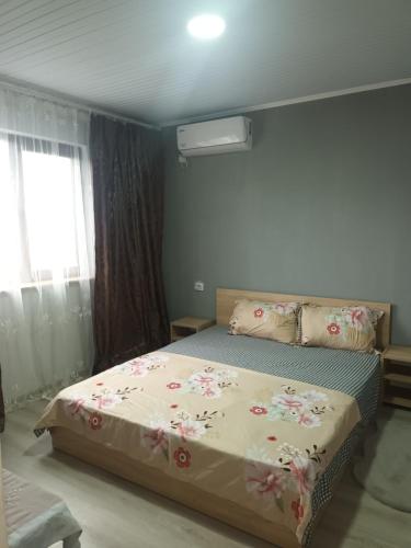 une chambre avec un lit avec des fleurs dessus dans l'établissement Cazare Corbu, à Corbu