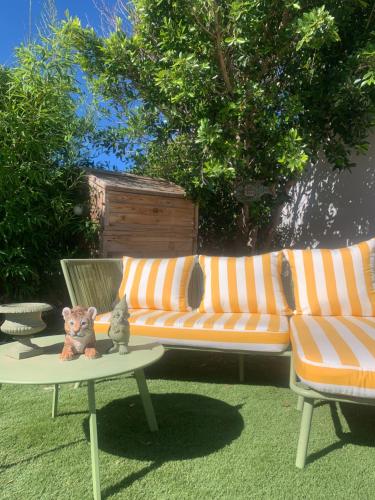 a couch and a table with a cat on a table at Villa Boho Cassis in Cassis
