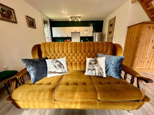 a yellow couch with two pillows on top of it at Gryfne Kaszuby in Kamienica Królewska