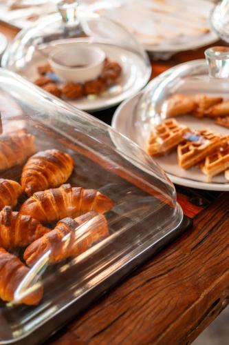 a table with plates of pastries and plates of food at The Garten Living in Paje