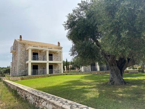 an old house with a tree in front of it at Green Hill in Valanidorachi