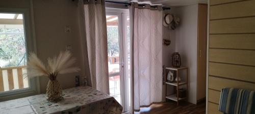 une chambre avec un vase sur une table à côté d'une fenêtre dans l'établissement Coquet mobilhome climatisé, à Villeneuve-lès-Maguelone