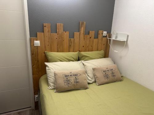 una cama con cabecero de madera y dos almohadas en Accès direct à la PLAGE de Mr HULOT Saint Marc sur Mer près de La Baule - Parking privé, en Saint-Nazaire