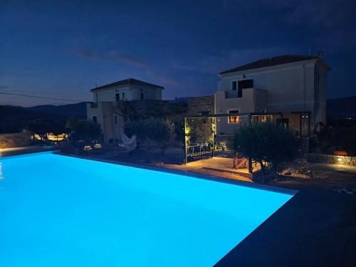 a swimming pool in front of a house at night at Studio Αυξώ Afxo in Galaxidhion
