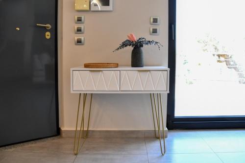 a white table with a vase on it next to a door at Terra Nova Luxury Villa in Mystras