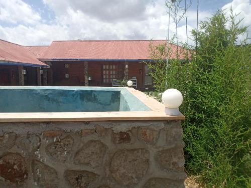 een zwembad voor een bakstenen gebouw bij Eco Farm in Karatu