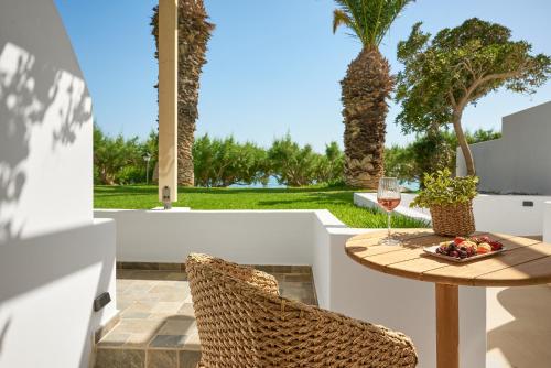 a table with a bowl of fruit and a glass of wine at Artemis in Makry Gialos