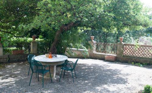 a table and chairs sitting under a tree at Usage exclusif - Palazzo du XVI avec piscine in Crespina
