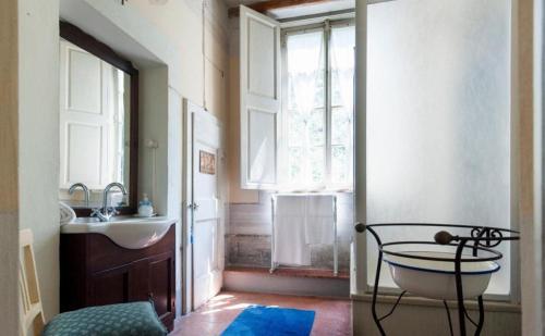 a bathroom with a sink and a tub and a window at Usage exclusif - Palazzo du XVI avec piscine in Crespina