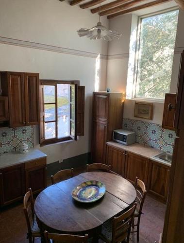 a kitchen with a wooden table with chairs and a table sidx sidx sidx at Usage exclusif - Palazzo du XVI avec piscine in Crespina