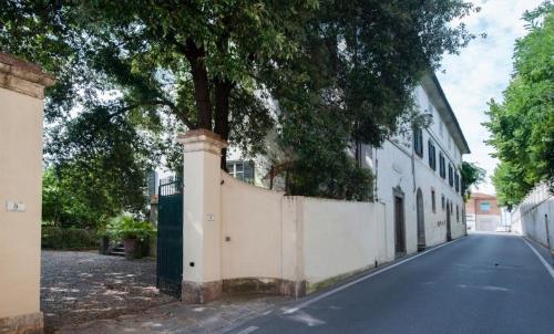 a tree on the side of a street next to a fence at Usage exclusif - Palazzo du XVI avec piscine in Crespina