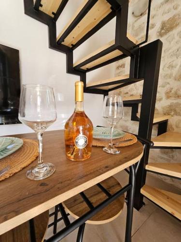 two wine glasses and a bottle on a table at Rafeio Roustic Maisonette in Episkopi (Heraklion)