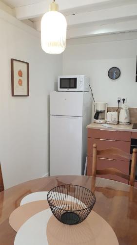une cuisine avec une table et un réfrigérateur blanc dans l'établissement Appartement T2, Caen centre, à Caen