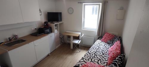 Cette chambre dispose d'une cuisine avec un canapé et une table. dans l'établissement Appartement cosy plein centre, à Conches-en-Ouche