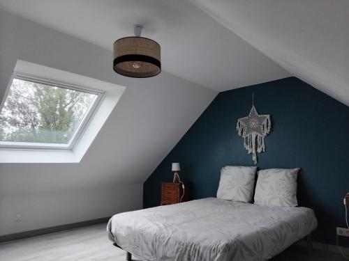 une chambre avec un lit avec un mur bleu dans l'établissement Ti Guernevez - Le Cottage, à Briec