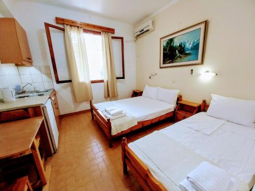 a room with two beds and a kitchen with a sink at MAKIS STUDIOS KATELIOS in Katelios