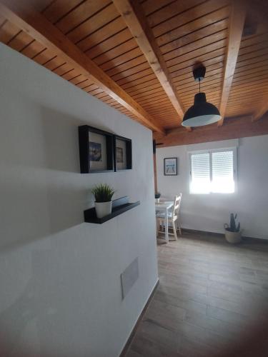 a living room with a wooden ceiling and a table at Roque in Las Playas