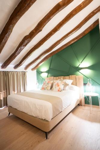 a bedroom with a large bed with a green wall at Cals Avis - Batea in Batea