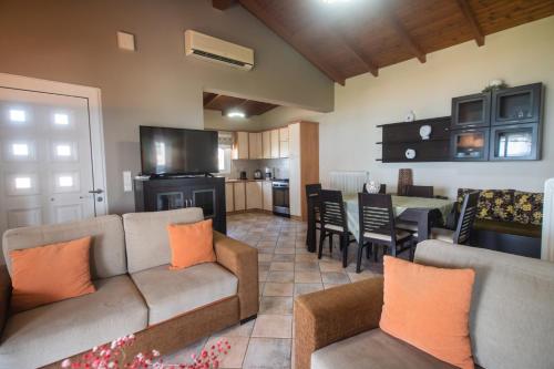 a living room with a couch and a dining room at Luxury Beach Villa in Skála