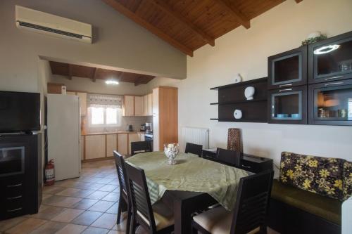 a kitchen and dining room with a table and chairs at Luxury Beach Villa in Skála