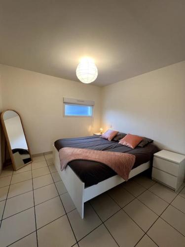 - une chambre avec un lit et un miroir dans l'établissement Petite maison indépendante, à La Chapelle-des-Fougeretz