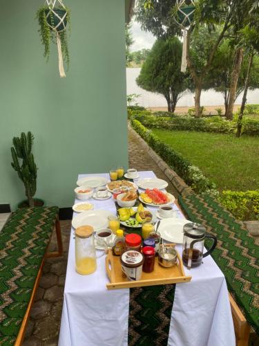 a table with plates of food on it at Tukutane Kilimanjaro - Homestay in Uru