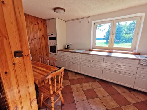 a large kitchen with a table and a window at Ośrodek Wypoczynkowy "U Kulasa" in Warchały