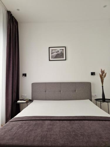 パランガにあるAmber Sea Apartment - 2の白いシーツが敷かれた大きなベッドのある寝室