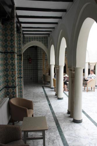 a hallway with chairs and tables in a building at Hôtel Medina in Sousse