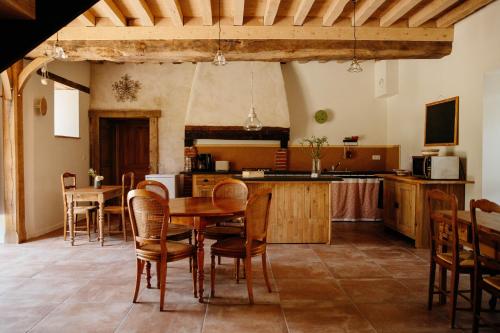 a kitchen and dining room with a table and chairs at Les Bucoliques de la Noë in Goven