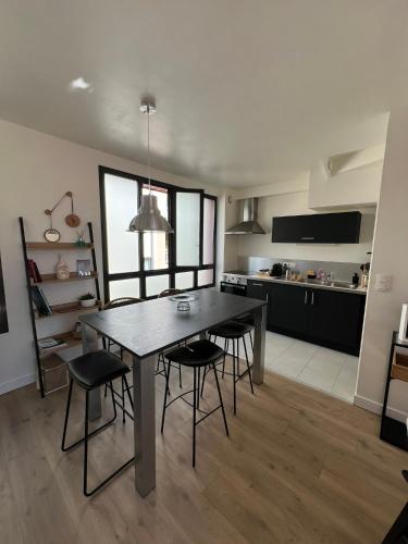 une cuisine et une salle à manger avec une table et des chaises dans l'établissement Duplex hypercentre, à Dinard