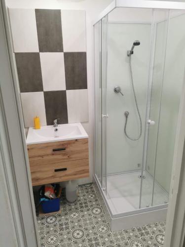 une salle de bain avec une douche en verre et un lavabo dans l'établissement Treportplage, au Tréport