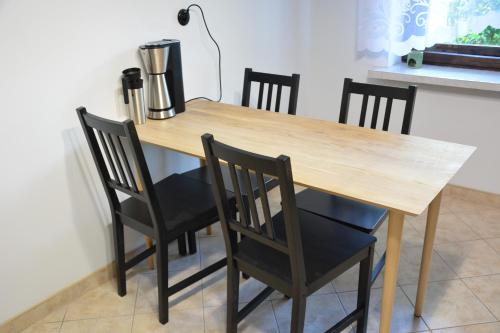 a wooden table with chairs and a blender on it at Magic Wood Guest House in Lidzbark Warmiński