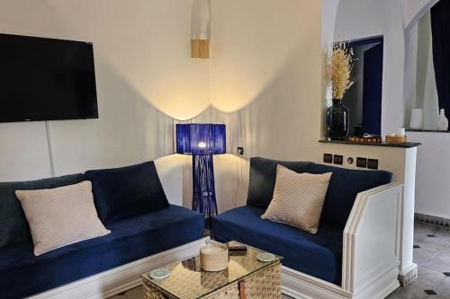 una sala de estar con 2 sofás azules y una lámpara. en La kasbah bleue, en Marrakech